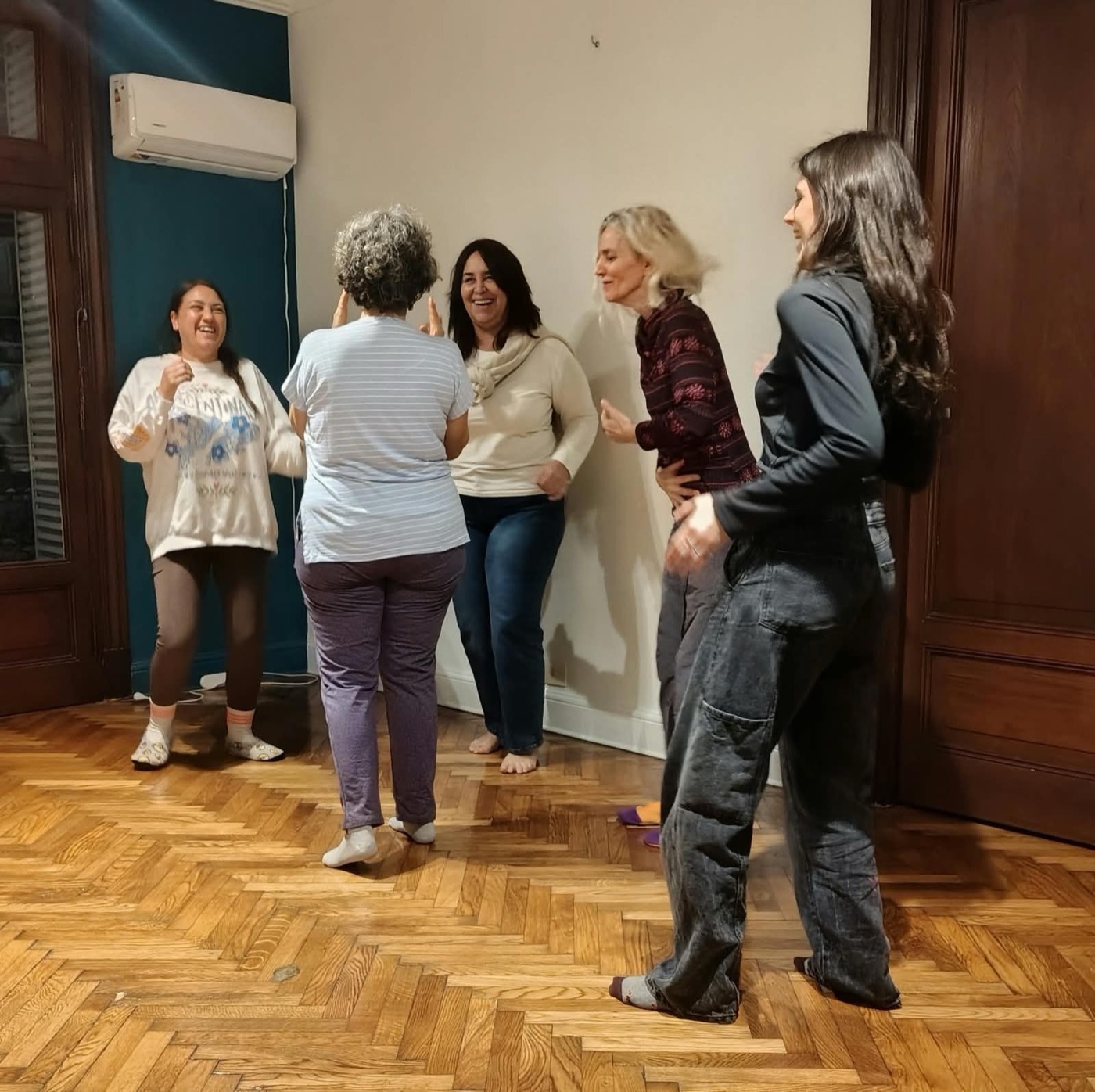 Integrantes de un grupo ríen en movimiento durante un ejercicio