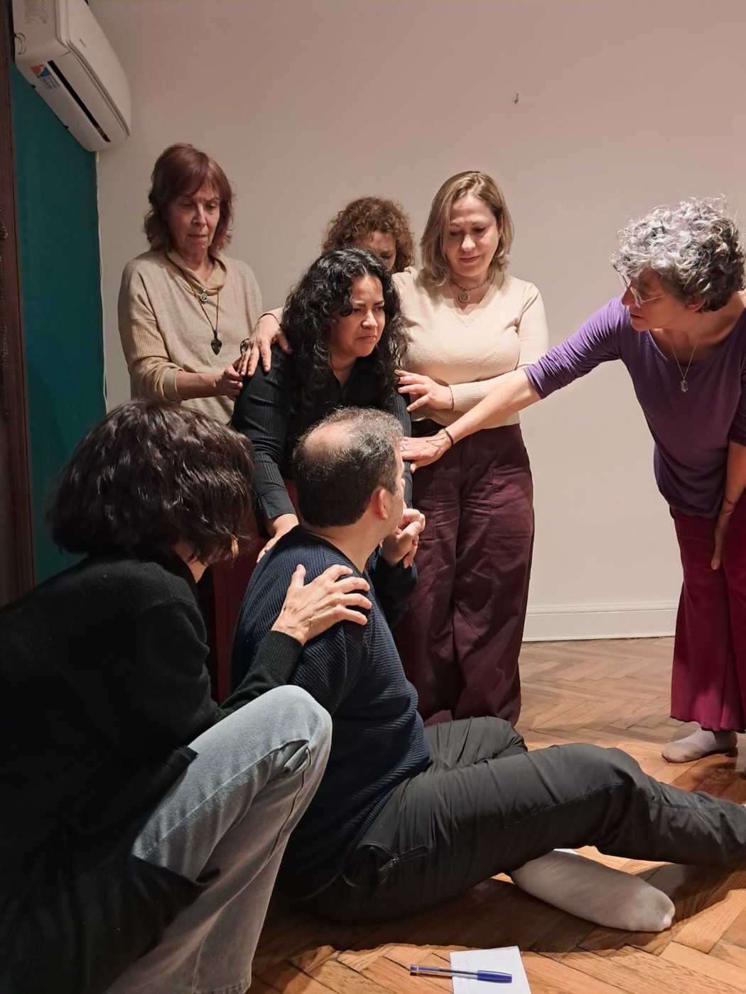 Un grupo rodea y sostiene a una integrante durante una escena de psicodrama